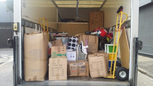 Entrance view of skip hire van and stacked skips at a Harlesden location